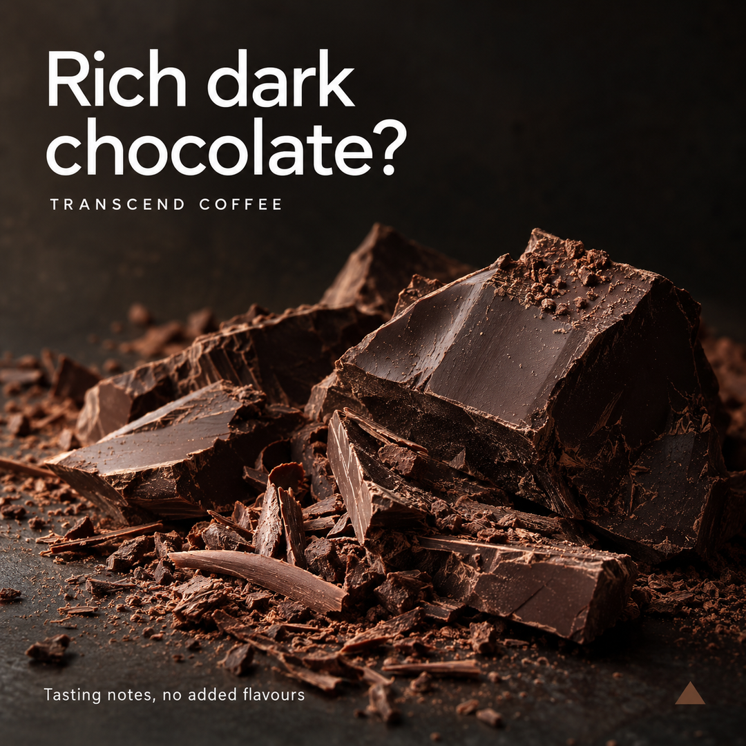 A close-up of broken dark chocolate pieces on a dark surface, with large white text reading 'Rich dark chocolate?' and smaller text 'TRANSCEND COFFEE' and 'Tasting notes, no added flavours'.